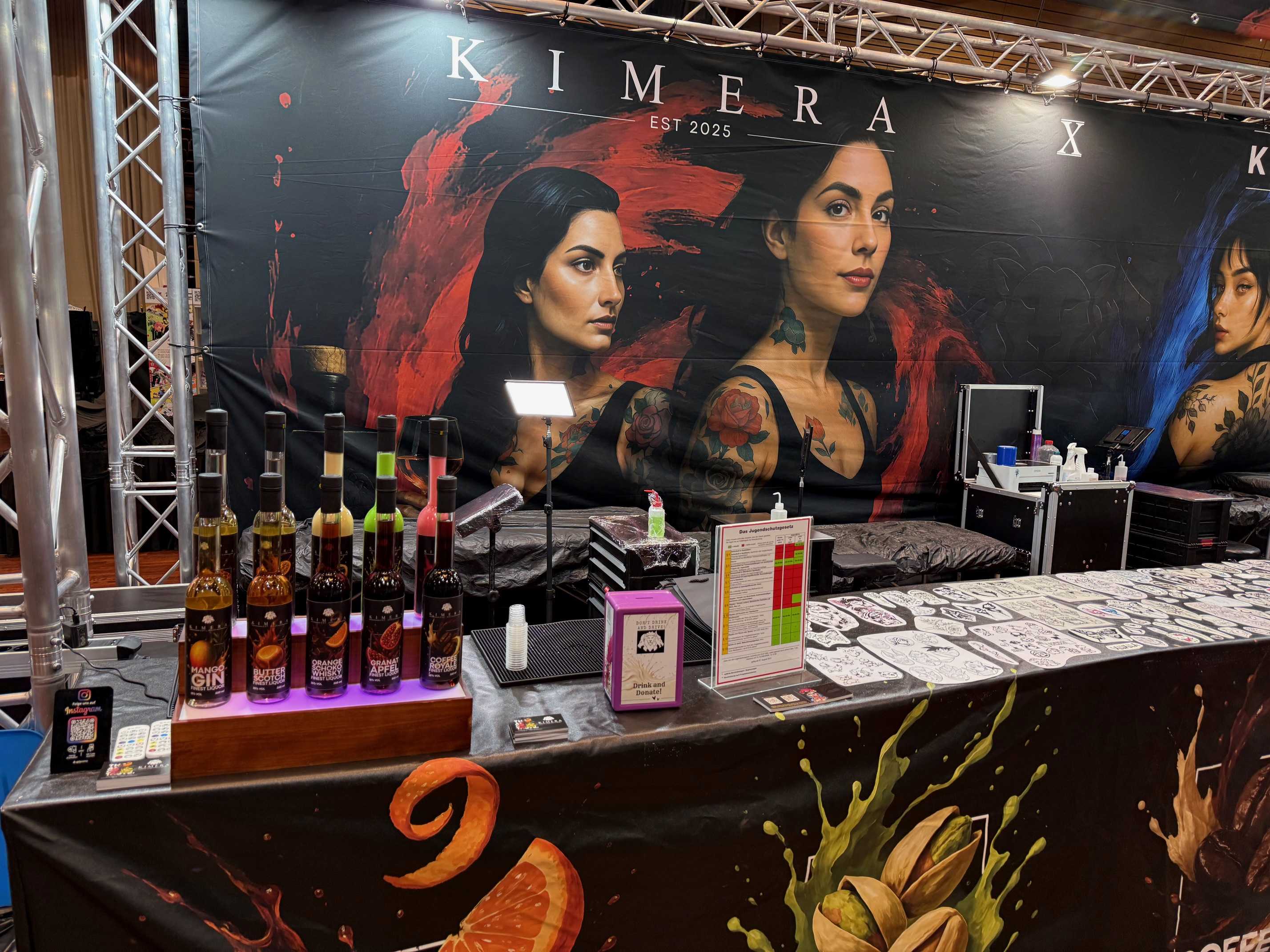 Messestand mit farbigem Banner, Getränkeflaschen und lebhaftem Dekor.